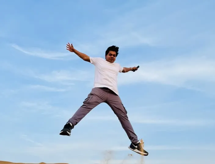 Jumping above the sand dunes during a desert trip.