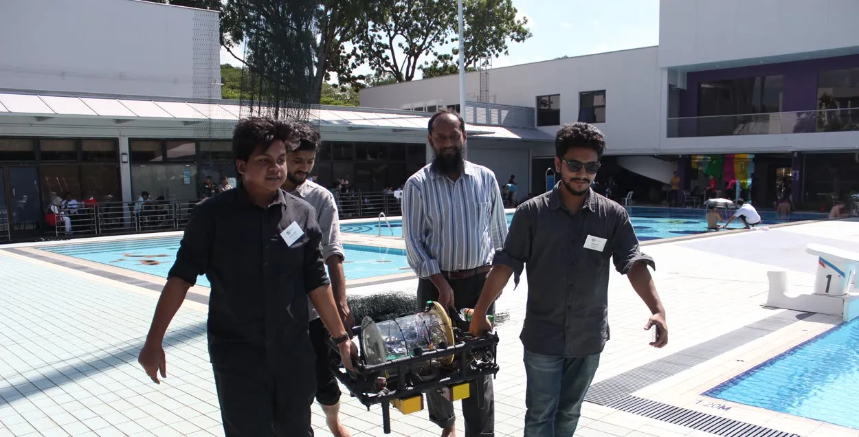Carrying the Duburi underwater robot after a pool test.